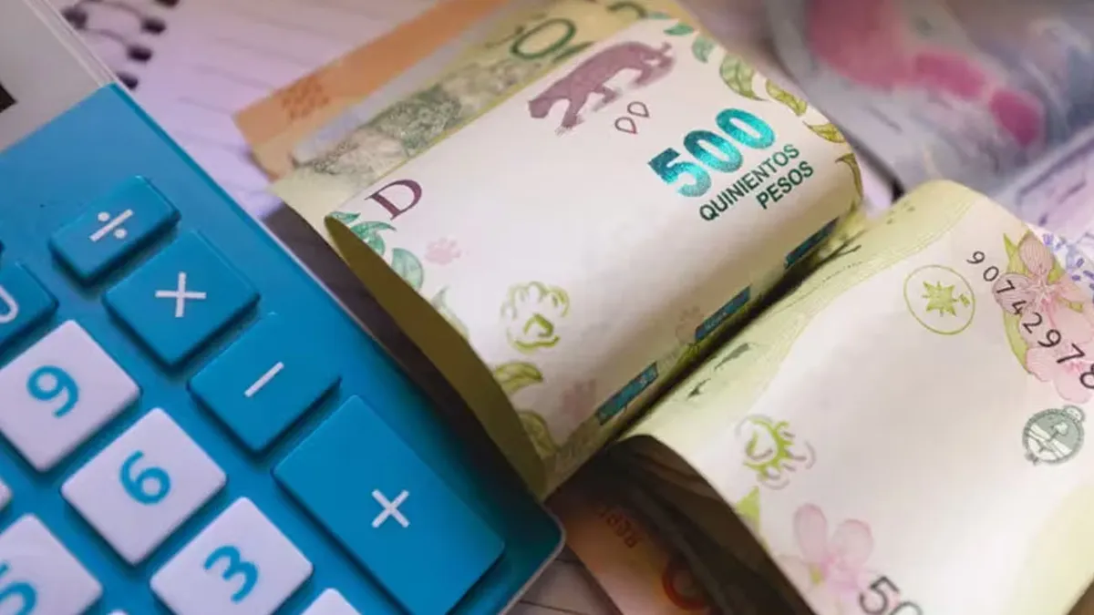 Una calculadora al lado de billetes de 500 pesos argentinos en una mesa.